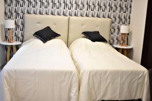 two beds with white sheets and black pillows at Loft para 4 personas 1º C in Buenos Aires