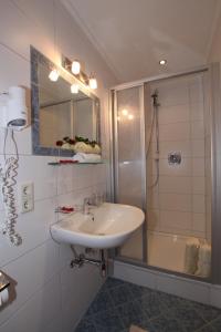 La salle de bains est pourvue d'un lavabo et d'une douche. dans l'établissement Haus Öttl, à Ischgl