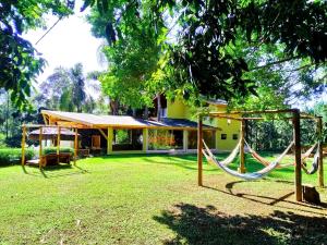 a backyard with a swing set and a house at Pousada Della Vegas in Serra Negra