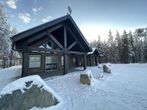 Eine Blockhütte im Schnee, im Hintergrund Bäume. in der Unterkunft Timber Lodge in Valemount