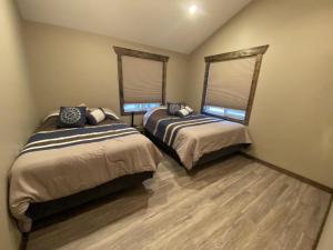 two beds in a room with two windows at Timber Lodge in Valemount