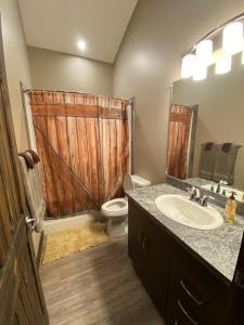 a bathroom with a toilet and a sink with a wooden door at Timber Lodge in Valemount