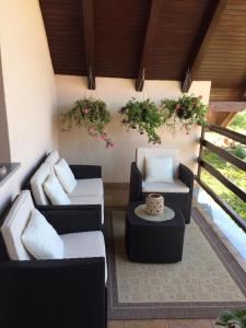 - un balcon avec 2 chaises, une table et des fleurs dans l'établissement Apartment Majetić, à Gornji Vaganac