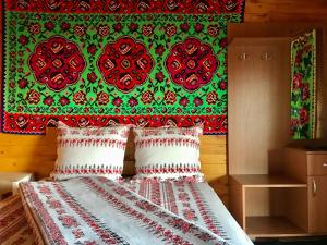 a bedroom with a bed with a red and green wall at Floare de Maramures 2 in Sighetu Marmaţiei