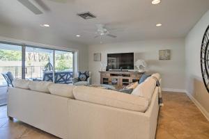 a living room with a large couch and a tv at Riviera Beach Home with Pool - Walk to Beaches! in Riviera Beach