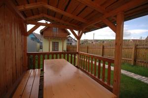 a wooden porch with a wooden bench on a deck at Víkendový domček Tis in Hrabušice