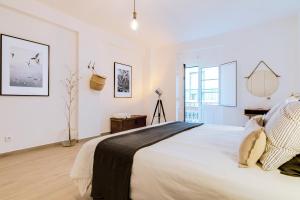 a white bedroom with a large bed and a window at Casa Oliva - Olhão in Olhão