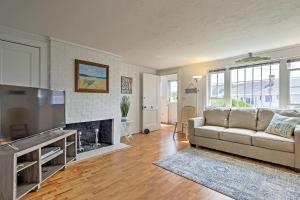 a living room with a couch and a television at Updated Cottage - 300 Feet to Craigville Beach! in Centerville
