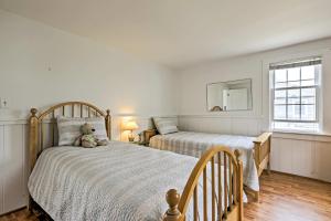 een slaapkamer met 2 bedden en een spiegel bij Updated Cottage - 300 Feet to Craigville Beach! in Centerville