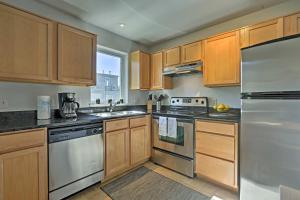 una cucina con armadietti in legno ed elettrodomestici in acciaio inossidabile di LoHi Apartment with Patio 1 Mi to Downtown Denver! a Denver