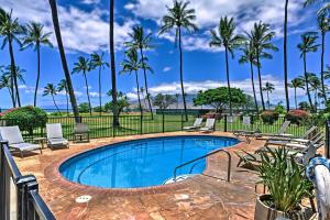 a swimming pool with chairs and palm trees at Beachside Kihei Vacation Rental with Stunning Views! in Kihei
