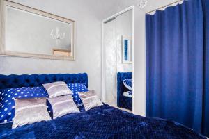 a bedroom with a blue bed with pillows on it at El Dorado Apartment z Jacuzzi in Wrocław