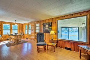 uma sala de estar com uma mesa e uma cadeira em Picturesque Cottage with Sunroom on Ashmere Lake! em Hinsdale