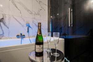 a bottle of champagne and two glasses on a table at El Dorado Apartment z Jacuzzi in Wrocław +24 photos