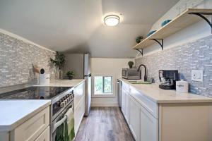 a kitchen with white appliances and a brick wall at Dtwn Golden Apt Less Than 9 Mi to Red Rocks Amphitheater! in Golden