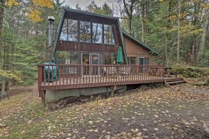 a cabin in the woods with a large window at Lakefront Berkshires Retreat with Deck, Dock and Boat! in Great Barrington