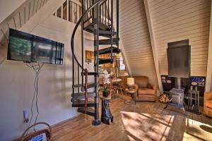 een woonkamer met een wenteltrap en een televisie bij One-Of-A-Kind Couples Getaway Big Bear A-Frame! in Sugarloaf