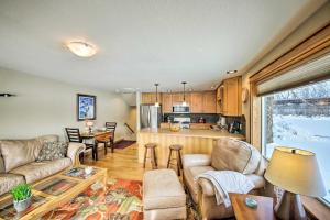 a living room with a couch and a table at Lake Pend Oreille Condo with Porch and Mountain View! in Sandpoint