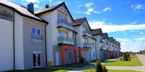 a row of apartment buildings on a street at Apartament Morski przy plazy in Darlowko