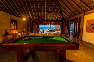 una mesa de billar en una habitación con vistas al océano en Casa Safran Vichayito en Los Órganos