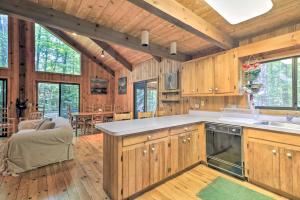 a kitchen with wooden cabinets and a living room at Cabin with 3 Acres, Tennis and BBall Courts by 4 Ski Mtns in Sandisfield