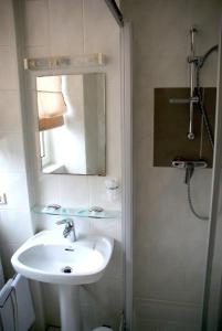 a bathroom with a sink and a shower with a mirror at Charly's Gare in Senningerberg