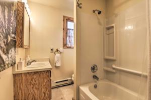 a bathroom with a sink and a tub and a toilet at Walk to Grand Lake Historic Dtwn Cabin! in Grand Lake