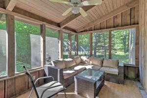 a screened in porch with a couch and a table at Cabin with 3 Acres, Tennis Courts By 4 Ski Mtns in Sandisfield