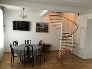 a dining room with a table and a spiral staircase at Appartment am Rathaus in Baden-Baden