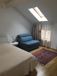 a bedroom with a bed and a blue chair at Appartment am Rathaus in Baden-Baden