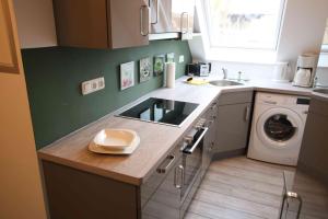 a kitchen with a sink and a washing machine at Ferienwohnung Heide in Scheeßel