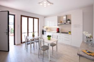uma cozinha com armários brancos e uma mesa e cadeiras em Le Rime em Arezzo
