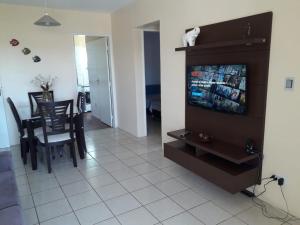 uma sala de estar com televisão e uma sala de jantar em APTº EM OLINDA CASA CAIADA em Olinda