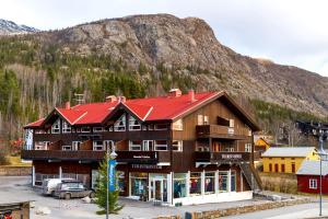 ein großes Gebäude mit einem Berg im Hintergrund in der Unterkunft Skiers Lodge 2 - Saga Apartments in Hemsedal