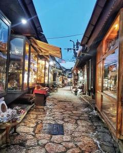 una calle adoquinada en un casco antiguo con tiendas en Apartman DINO en Sarajevo
