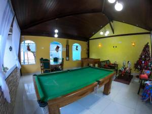 a room with a pool table and a christmas tree at Pousada Larissa in Paraty