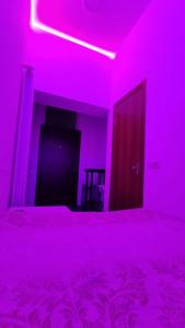 a bedroom with a bed with a pink light at Мини Смарт квартира с отдельным входом возле Посольства Америки США и НМАПО им Шупика Mini Smart apartment near the Embassy of USA and NMAPO in Kyiv