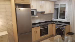 a kitchen with a refrigerator and a dishwasher at Casco Histórico, con Parking incluido in Zaragoza
