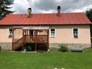 ein Haus mit einem roten Dach und einer Terrasse in der Unterkunft Chalupa u Jakuba in Liptovské Revúce