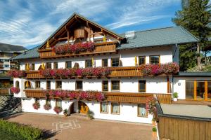 ein großes weißes Gebäude mit Blumen auf den Balkonen in der Unterkunft Haus Anemone in Serfaus