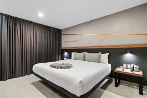 a bedroom with a large white bed and a table at Bedford Hotel in Querétaro +47 photos