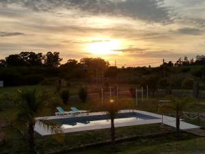 a swimming pool with a sunset in the background at María Fabiana in Concepción del Uruguay