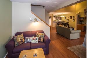 sala de estar con sofá púrpura y cocina en Pinnacle E26, en Killington