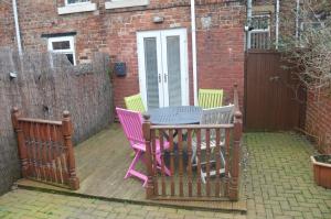 a patio with four chairs and a table on a deck at 8 bed house 2 miles (7 Mins) from Newcastle centre in Newcastle upon Tyne