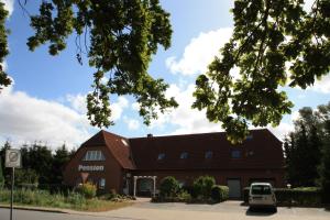 a barn with a car parked in front of it at Pension vorm Darß in Hirschburg