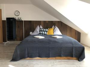 a bedroom with a large bed with a black comforter at Apartment ROCI in Šlapanice