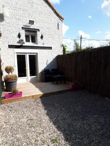 una terraza de madera frente a una casa blanca en Au Paradis des Crins avec un studio rez de chaussée jardin et studio en duplex avec terrasse, en Templeuve