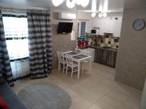 a living room with a table and a kitchen at Luxuri apartments in Chernihiv
