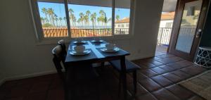 una mesa con tazas y platillos con vistas al océano en Sand Castle en Imperial Beach