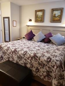 a bedroom with a large bed with purple pillows at 627 on King B&B in Niagara on the Lake